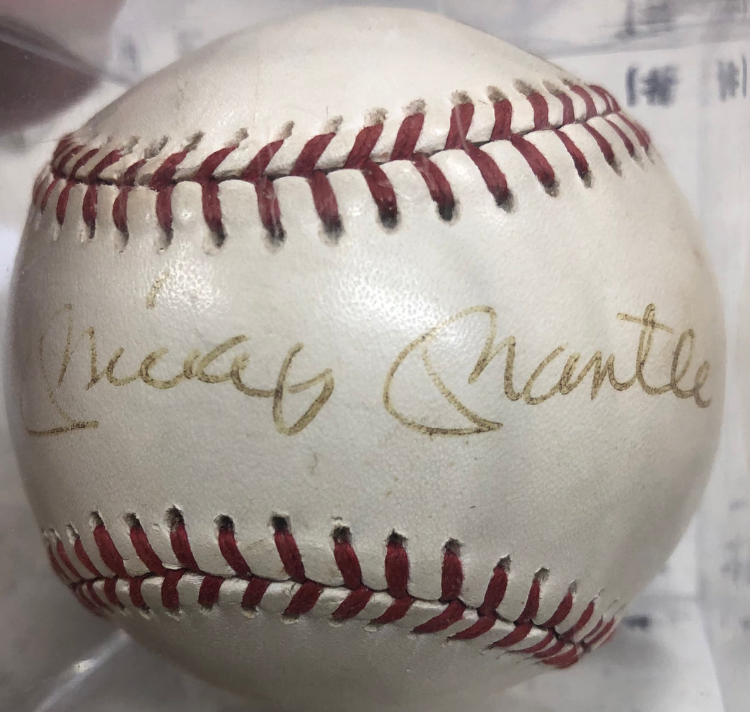 A pristine Mickey Mantle signed baseball in near-mint condition, showcasing a bold, dark signature on clean white leather.